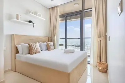 a bedroom with a large bed with a large window at Aykon City 2BR Luxury Stay Close to Downtown in Dubai