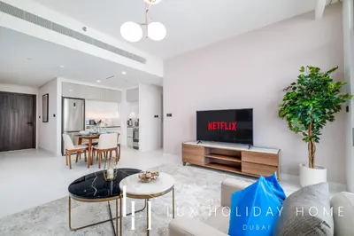 a living room with a couch and a tv at LUX The Marina Vista Beachfront Suite 5 in Dubai