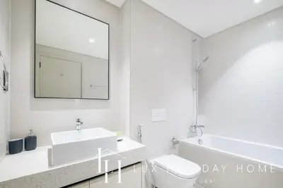 a white bathroom with a sink and a mirror at LUX The Marina Vista Beachfront Suite 5 in Dubai