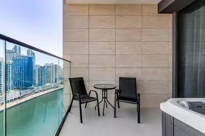 two chairs and a table on the balcony of a building at Luxury Studio with Jacuzzi & Canal Views in Dubai