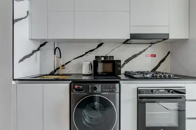 a kitchen with a washing machine and a microwave at Luxury Studio with Jacuzzi & Canal Views in Dubai