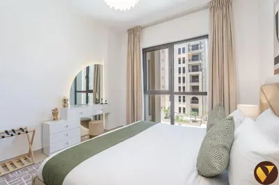 a bedroom with a large bed and a large window at Vogue Madinat Jumeirah Living Jadeel near Burj AlArab, One-Bedroom Apartment with Large Balcony and Pool View, Access to All Amenities in Dubai