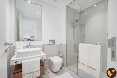 a bathroom with a sink and a toilet and a shower at Vogue Madinat Jumeirah Living Jadeel near Burj AlArab, One-Bedroom Apartment with Large Balcony and Pool View, Access to All Amenities in Dubai