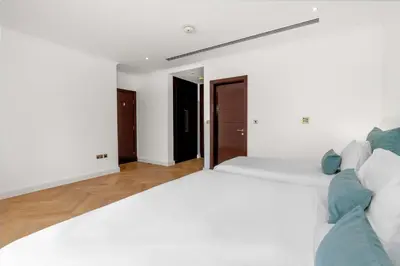 a bedroom with a large white bed with blue pillows at Elite Villa in Dubai in Dubai