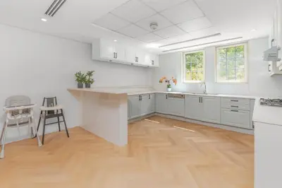 a kitchen with white cabinets and a wooden floor at Elite Villa in Dubai in Dubai