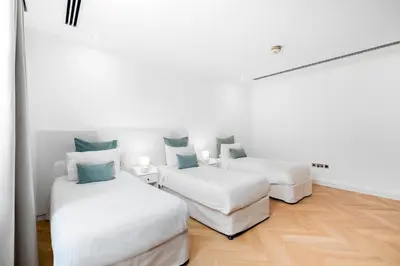 two beds in a white room with blue pillows at Elite Villa in Dubai in Dubai