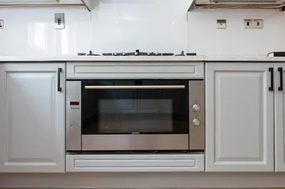 a kitchen with a stainless steel oven with white cabinets at Elite Villa in Dubai in Dubai