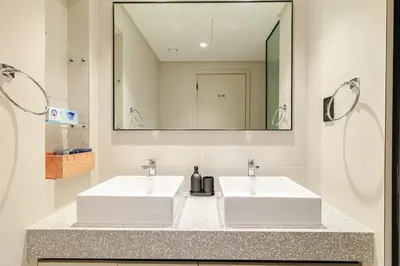two white sinks in a bathroom with a mirror at 2BR-Beach Access - Stunning Marina&Palm View in Dubai