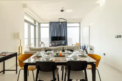 a dining room with a table and chairs and a couch at 2BR-Beach Access - Stunning Marina&Palm View in Dubai