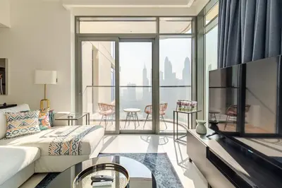 a living room with a couch and a view of the city at 2BR-Beach Access - Stunning Marina&Palm View in Dubai