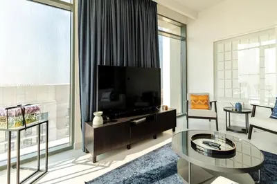 a living room with a tv and a large window at 2BR-Beach Access - Stunning Marina&Palm View in Dubai