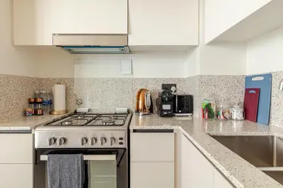 a kitchen with a stove and white cabinets at 2BR-Beach Access - Stunning Marina&Palm View in Dubai