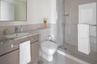 a bathroom with a toilet and a shower and a sink at Frank Porter - Forte Tower 1 in Dubai