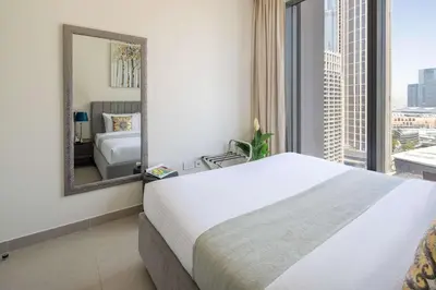 a bedroom with a large bed and a mirror at Frank Porter - Forte Tower 1 in Dubai