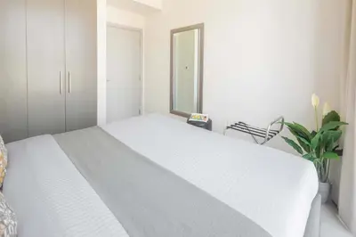 a white bedroom with a large white bed in it at Frank Porter - Forte Tower 1 in Dubai