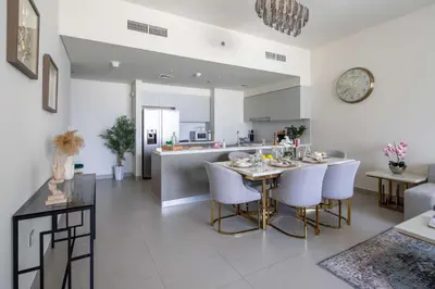 a kitchen and living room with a table and chairs at Frank Porter - Forte Tower 1 in Dubai