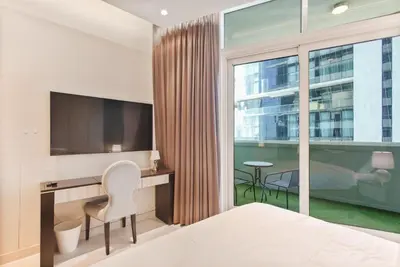 a hotel room with a bed and a desk and a television at studio in downtown Damac upper crest next to dubai mall in Dubai