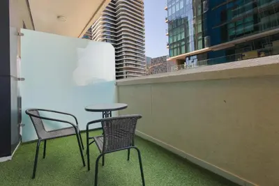 two chairs and a table on a balcony with buildings at studio in downtown Damac upper crest next to dubai mall in Dubai
