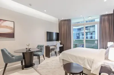 a hotel room with a bed and a table and chairs at studio in downtown Damac upper crest next to dubai mall in Dubai