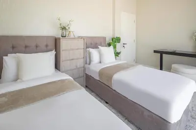 a bedroom with two beds and a desk at Frank Porter - Kappa Acca 3 in Dubai