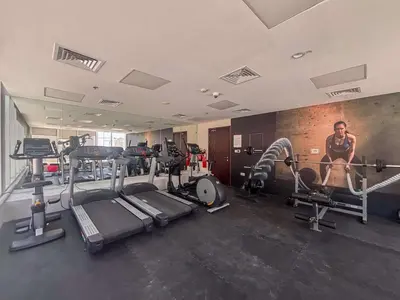 a gym with several tread machines and a man in the gym at Frank Porter - Kappa Acca 3 in Dubai