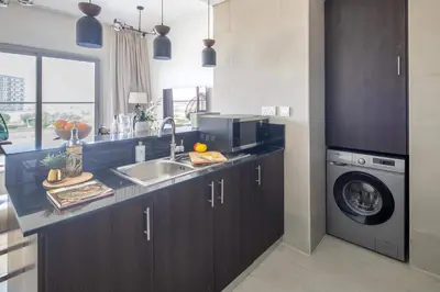 a kitchen with a sink and a washing machine at Frank Porter - Kappa Acca 3 in Dubai