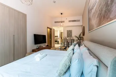 a bedroom with a large bed with blue pillows at HAVN - Studio in La Riviera Azure JVC, Pool View in Dubai