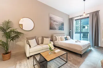 a living room with a couch and a table at HAVN - Studio in La Riviera Azure JVC, Pool View in Dubai