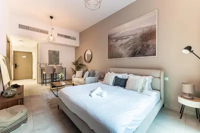 a bedroom with a bed and a living room at HAVN - Studio in La Riviera Azure JVC, Pool View in Dubai