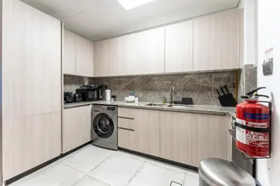 a kitchen with a washer and a washing machine at HAVN - Studio in La Riviera Azure JVC, Pool View in Dubai
