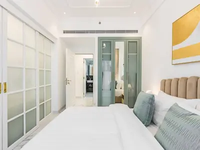 a white bedroom with a large white bed and a room at Arjan 1BR Near Miracle Garden Pool & Parking in Dubai