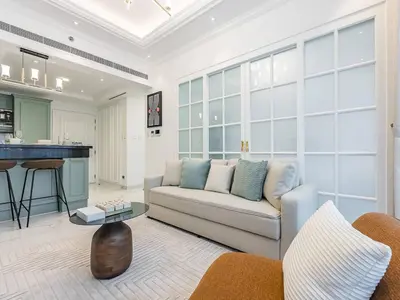 a living room with a couch and a table at Arjan 1BR Near Miracle Garden Pool & Parking in Dubai