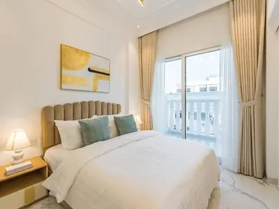 a bedroom with a bed and a large window at Arjan 1BR Near Miracle Garden Pool & Parking in Dubai