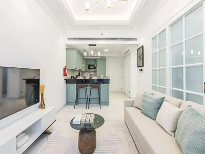 a living room with a couch and a table at Arjan 1BR Near Miracle Garden Pool & Parking in Dubai