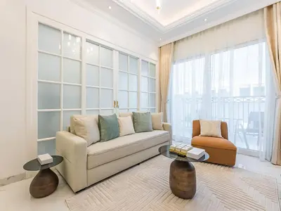 a living room with a couch and a chair at Arjan 1BR Near Miracle Garden Pool & Parking in Dubai