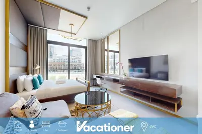 a hotel room with a bed and a television at Signature Livings - Bright Studio in JVC in Dubai