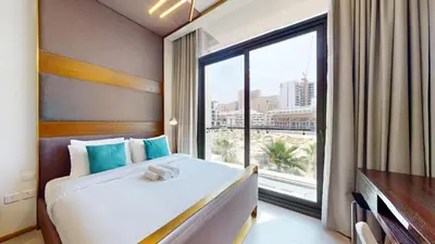 a hotel room with a bed and a large window at Signature Livings - Bright Studio in JVC in Dubai