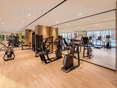 a gym with treadmills and exercise equipment in a building at Binghatti Emerald, Jumeirah Village Circle in Dubai