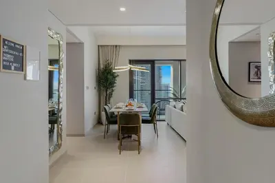 a dining room with a table and a mirror at Tranquil & Modern 2BR - Vida Residence Creek Beach in Dubai