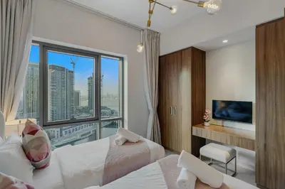 a bedroom with a bed and a large window at Tranquil & Modern 2BR - Vida Residence Creek Beach in Dubai