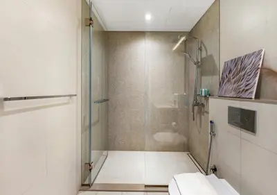 a bathroom with a shower and a toilet at La Vie Beachside Elegance in Dubai
