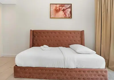 a bedroom with a bed with a brown headboard at La Vie Beachside Elegance in Dubai