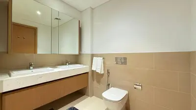 a bathroom with a toilet and a sink and a mirror at Premium 2 Bedroom at Creek Horizon in Dubai
