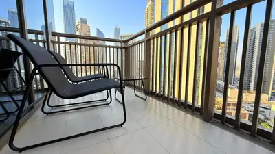 a chair on a balcony with a view of a city at Premium 2 Bedroom at Creek Horizon in Dubai