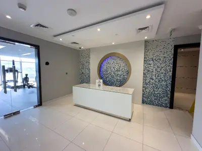 a lobby with a reception desk and a window at Stylish 2BR Retreat in JVC in Dubai