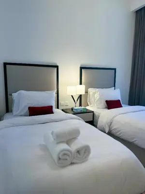 a hotel room with two beds with towels on them at Stylish 2BR Retreat in JVC in Dubai