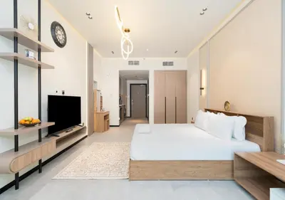 a bedroom with a large bed and a tv at Burj View - Luxury Studio - Near Dubai Miracle & Butterfly Garden- Arjan, Dubailand in Dubai