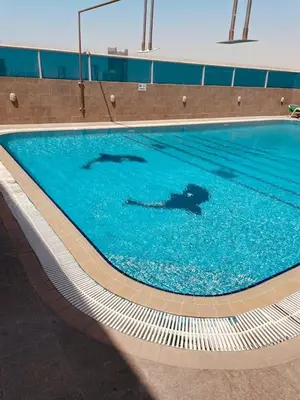 two people swimming in a swimming pool at Sport City with gym, pool, sauna in Dubai