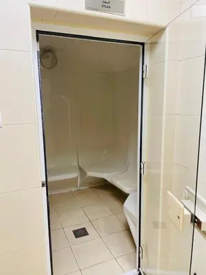 a bathroom with a toilet and a glass door at Sport City with gym, pool, sauna in Dubai
