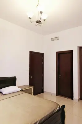a bedroom with a bed and two doors at Sport City with gym, pool, sauna in Dubai